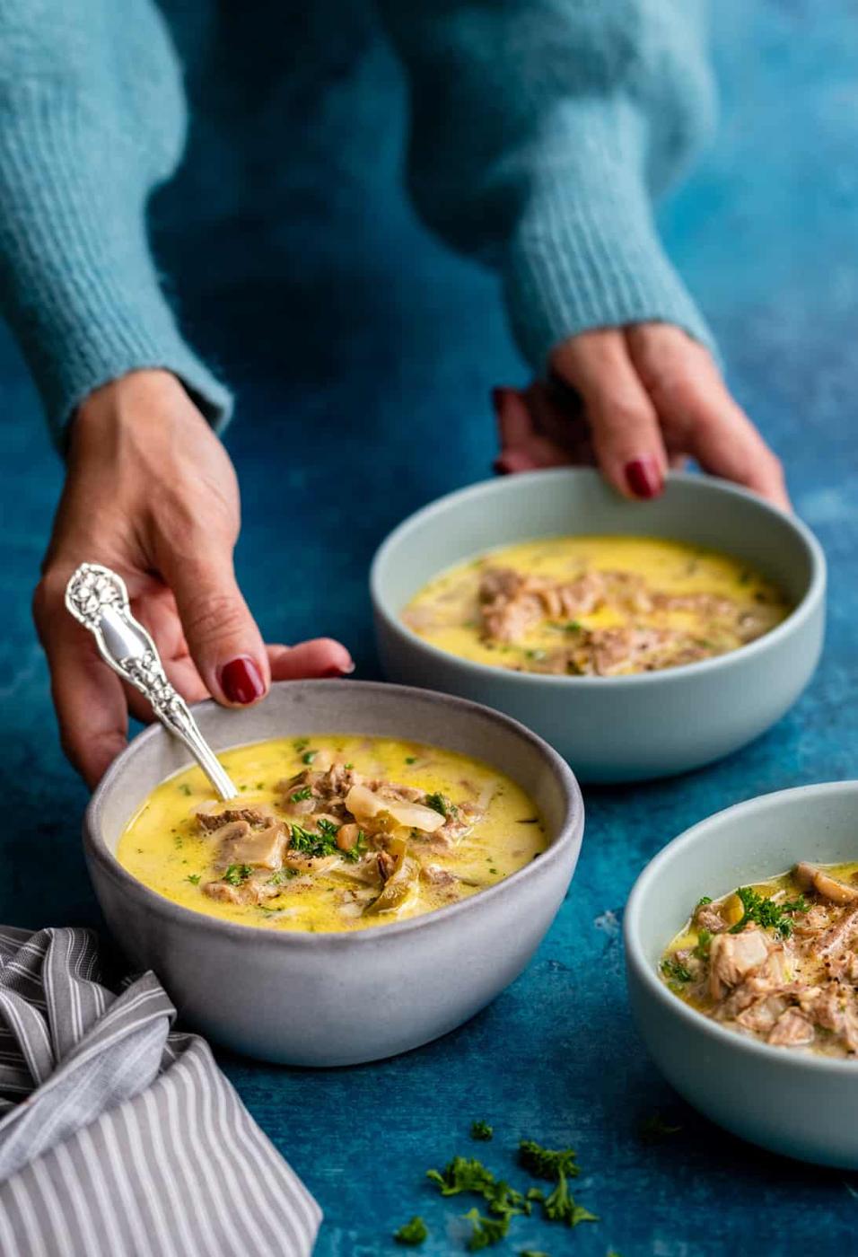 three bowls of Philly Cheesesteak Soup against a blue background