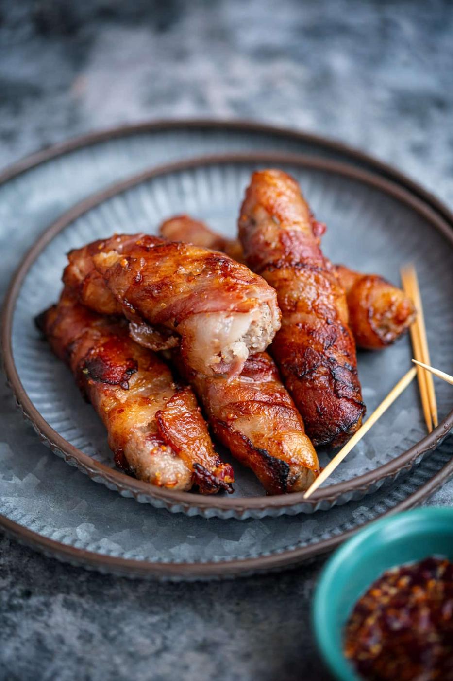 pigs in blankets with brie and cranberry on a plate, one with bite taken out