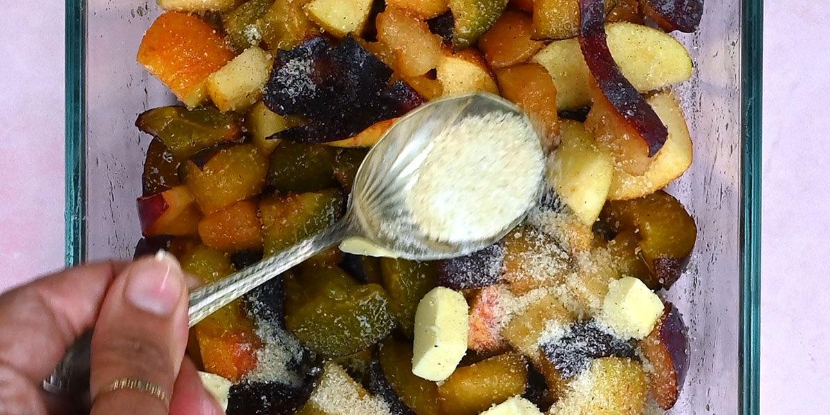 sprinkling chopped plums and apples with sugar