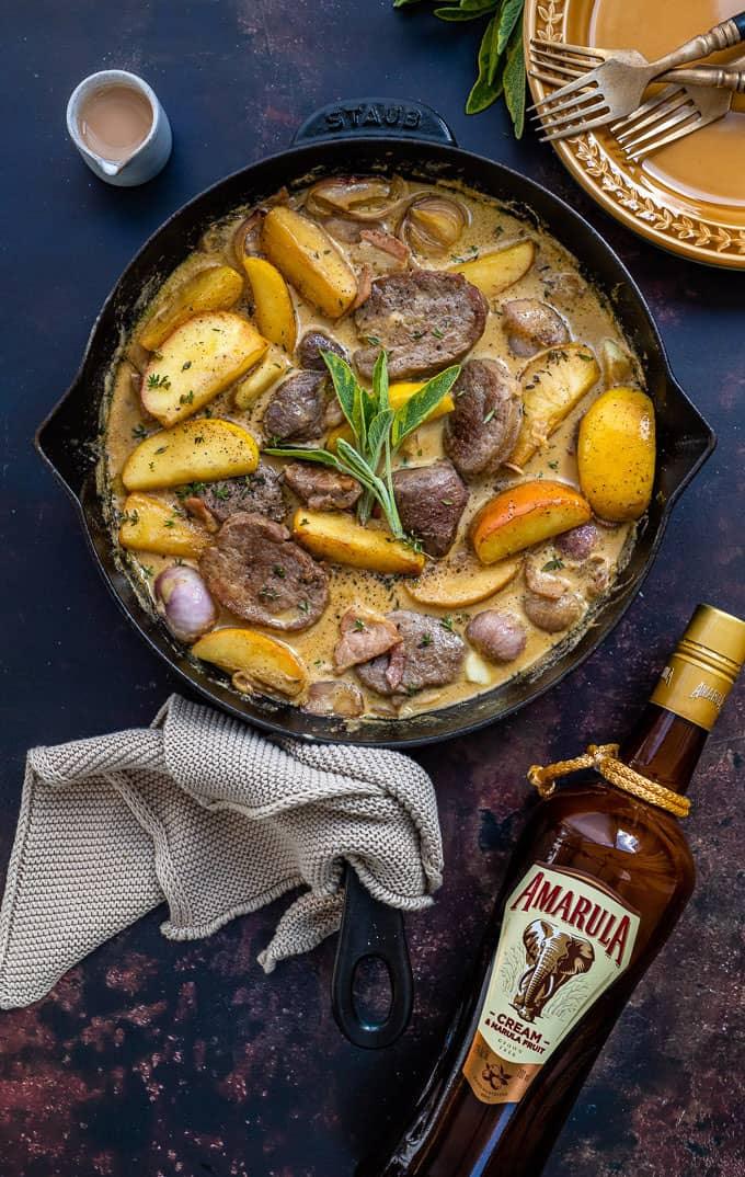 Skillet of pan fried pork tenderloin with apples in a creamy sauce