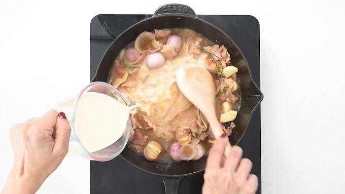 Pouring cream into pan for creamy pork sauce