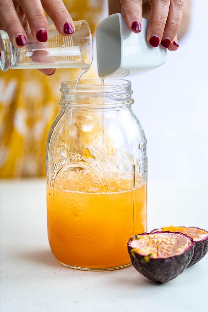 Making a virgin pornstar martini with passion fruit and apple juice