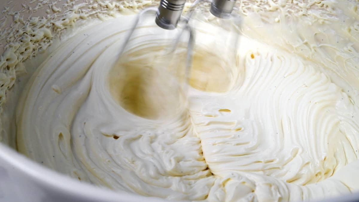 Close up on creamy frosting being whipped in a bowl