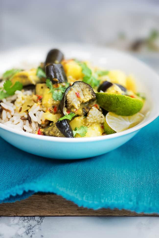 A bowl of rice topped with vegan eggplant and potato curry