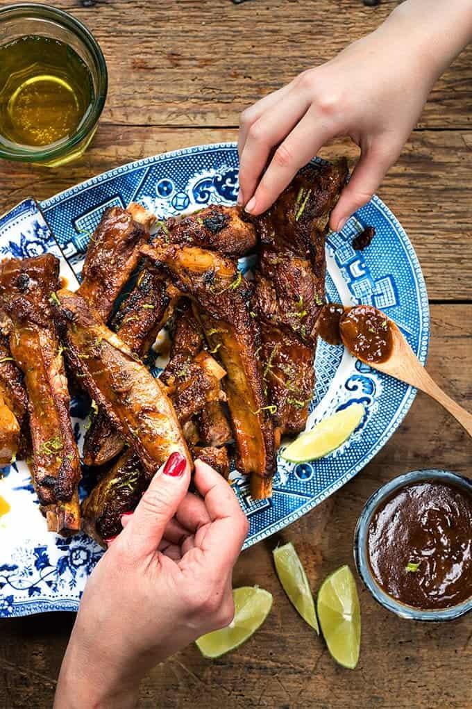 Hands reaching for Korean pork ribs overhead view