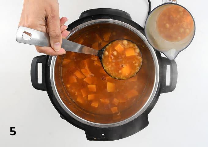 Transferring a ladleful of vegan soup to a jug for blending