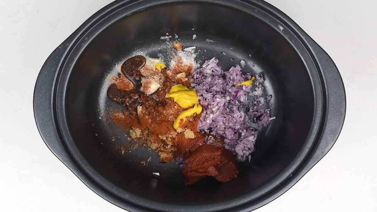 Adding ingredients for pulled chicken into slow cooker