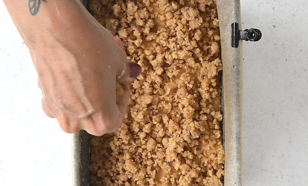 topping pumpkin apple bread with streusel prior to baking