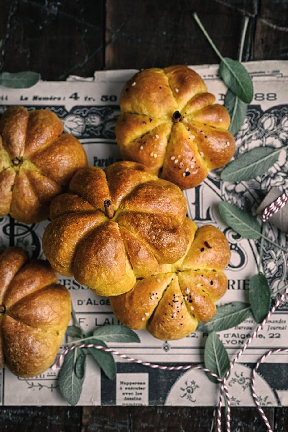 pumpkin shaped bread rolls with sage leaves on the side