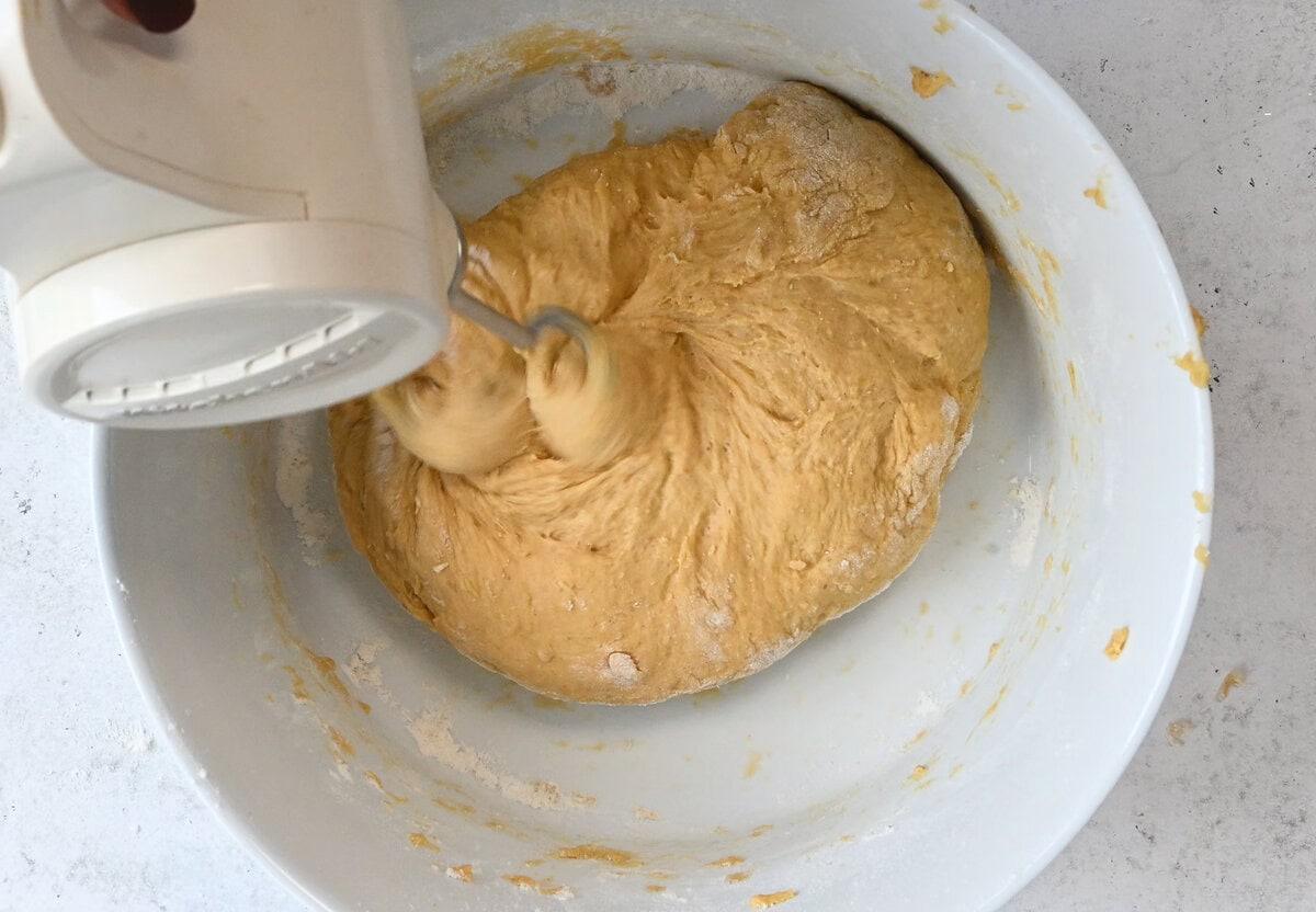 beating pumpkin bread dough with a hand mixer