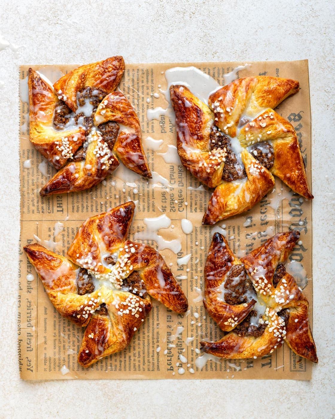 Homemade pinwheel Danish pastries with maple pecan filling and a glaze drizzle