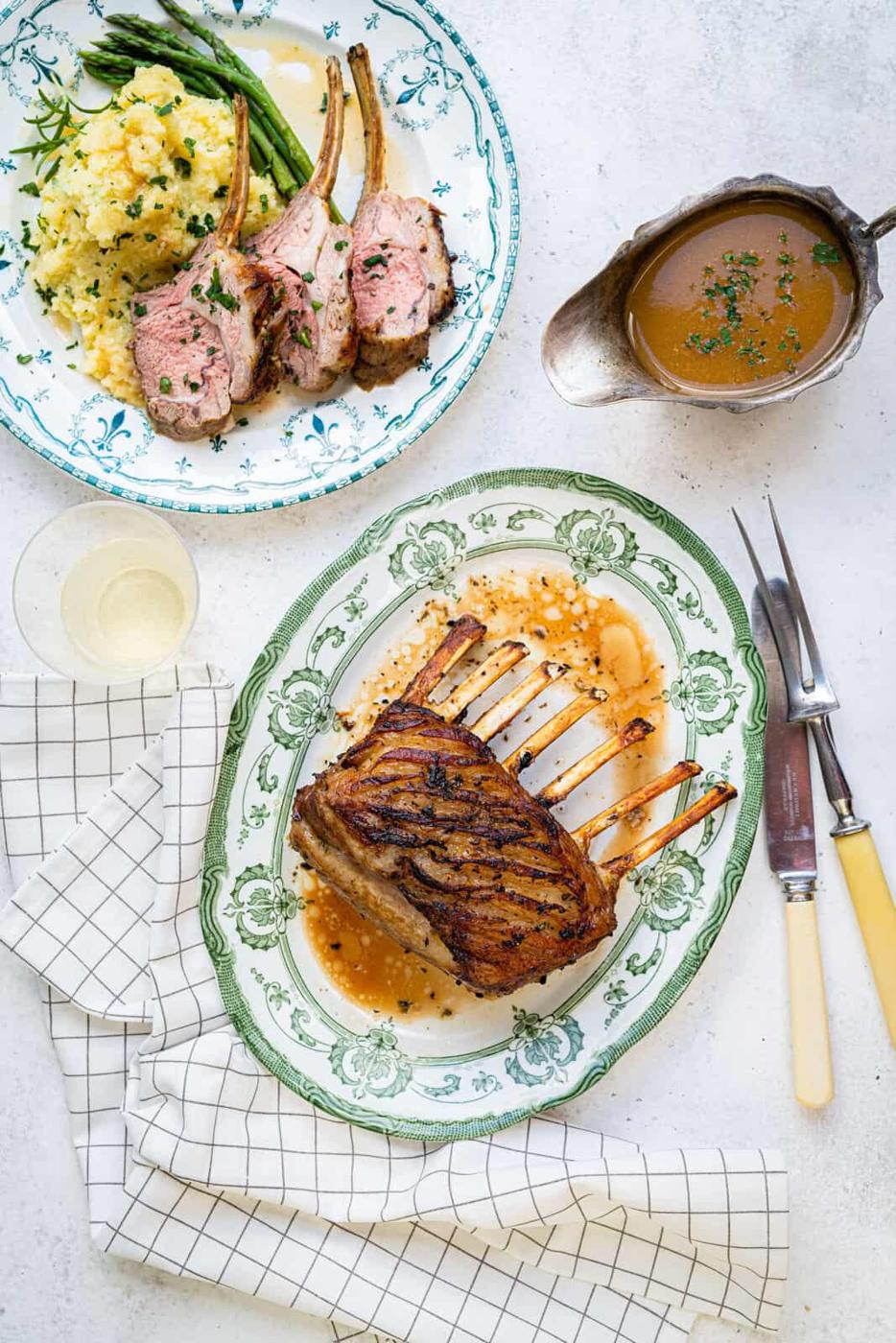 Overhead shot of rack of lamb on a platter with a plate on side
