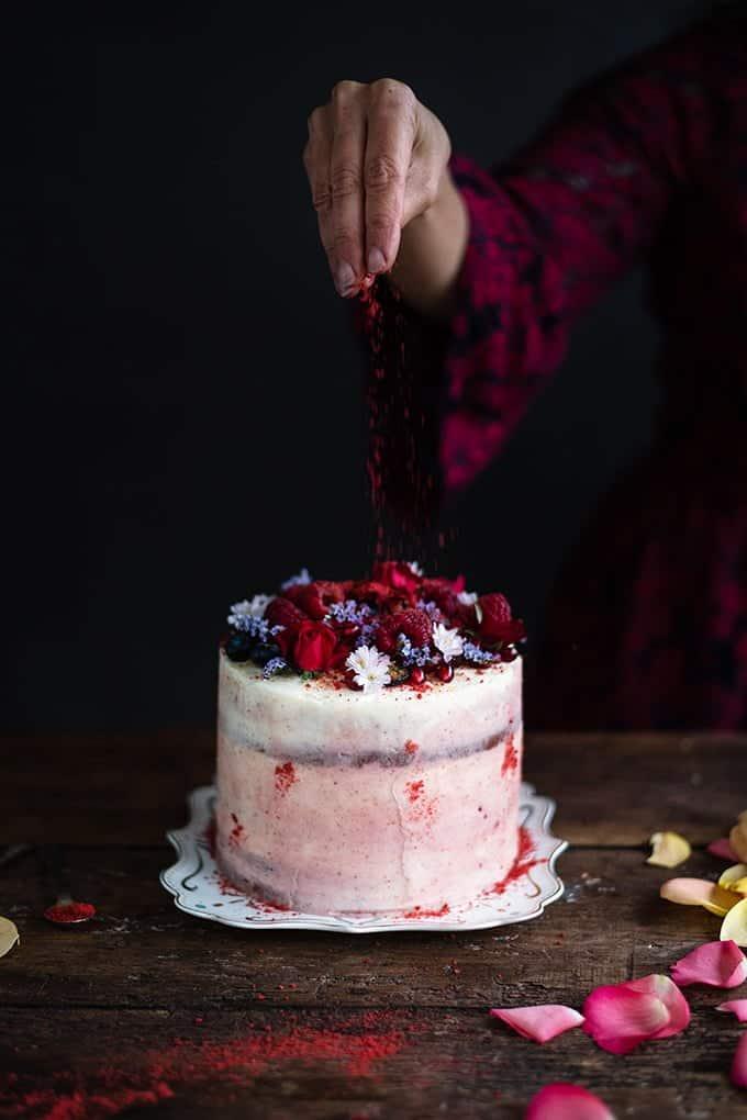 Red velvet layer cake decorated with flowers and berries