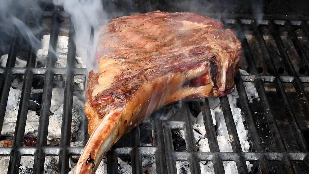steak smoking on a grill