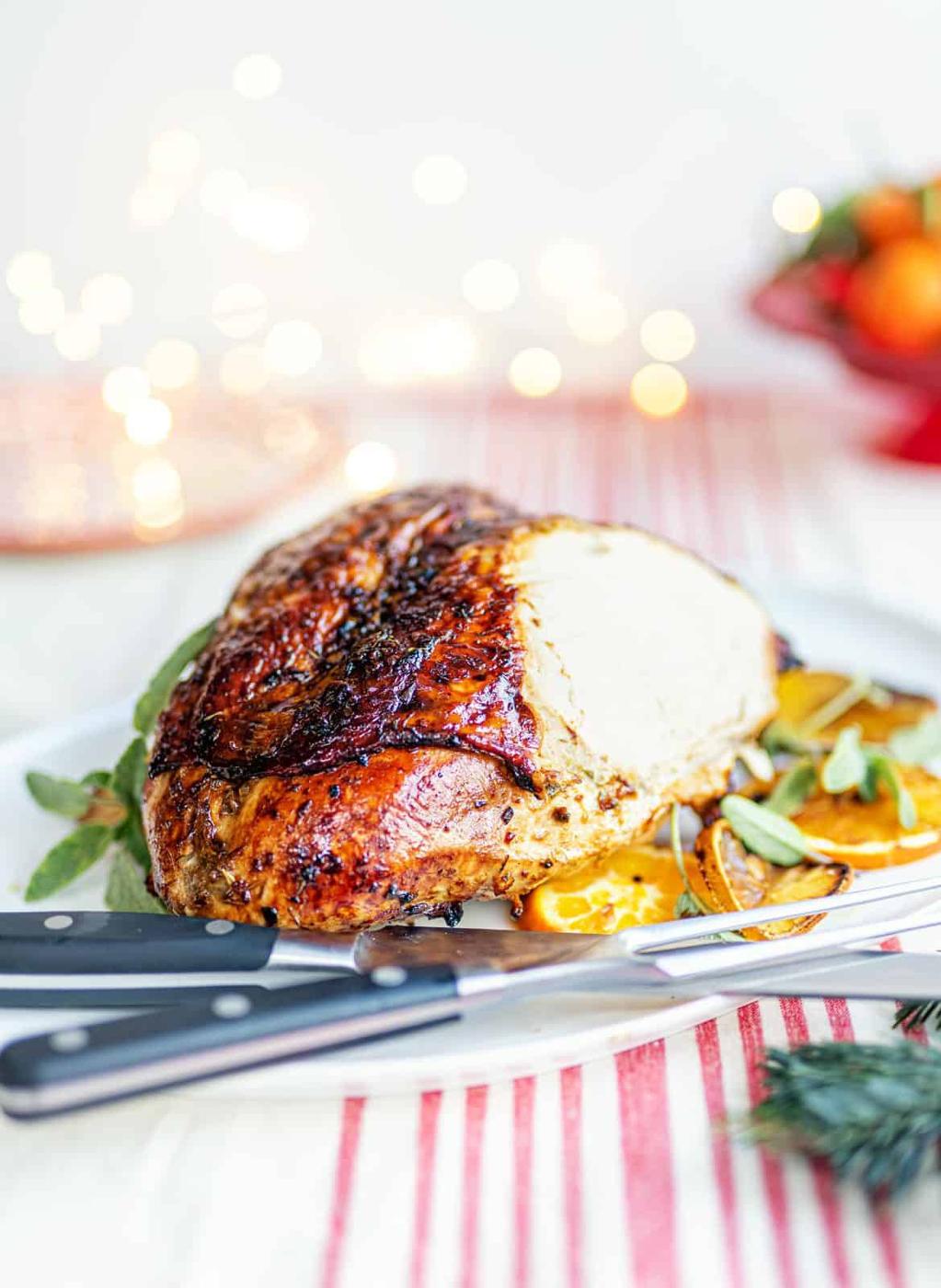 Sliced roast turkey crown on a white platter