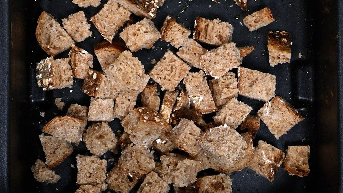 cubed wholemeal bread in an air fryer basket