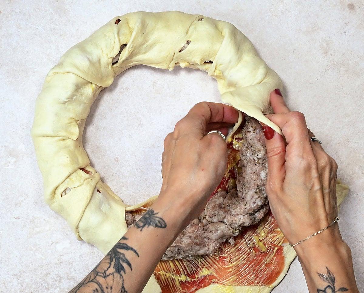 covering sausage meat in crescent roll dough