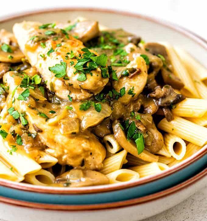 Bowl of chicken stroganoff with mushrooms served over penne pasta