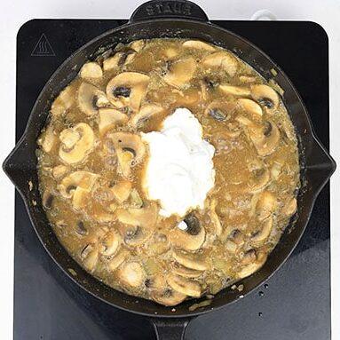 Dollop of Quark added to the mushroom sauce in a cast iron skillet