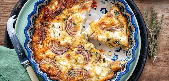 crustless vegetarian quiche, sliced in a patterned ceramic pie dish
