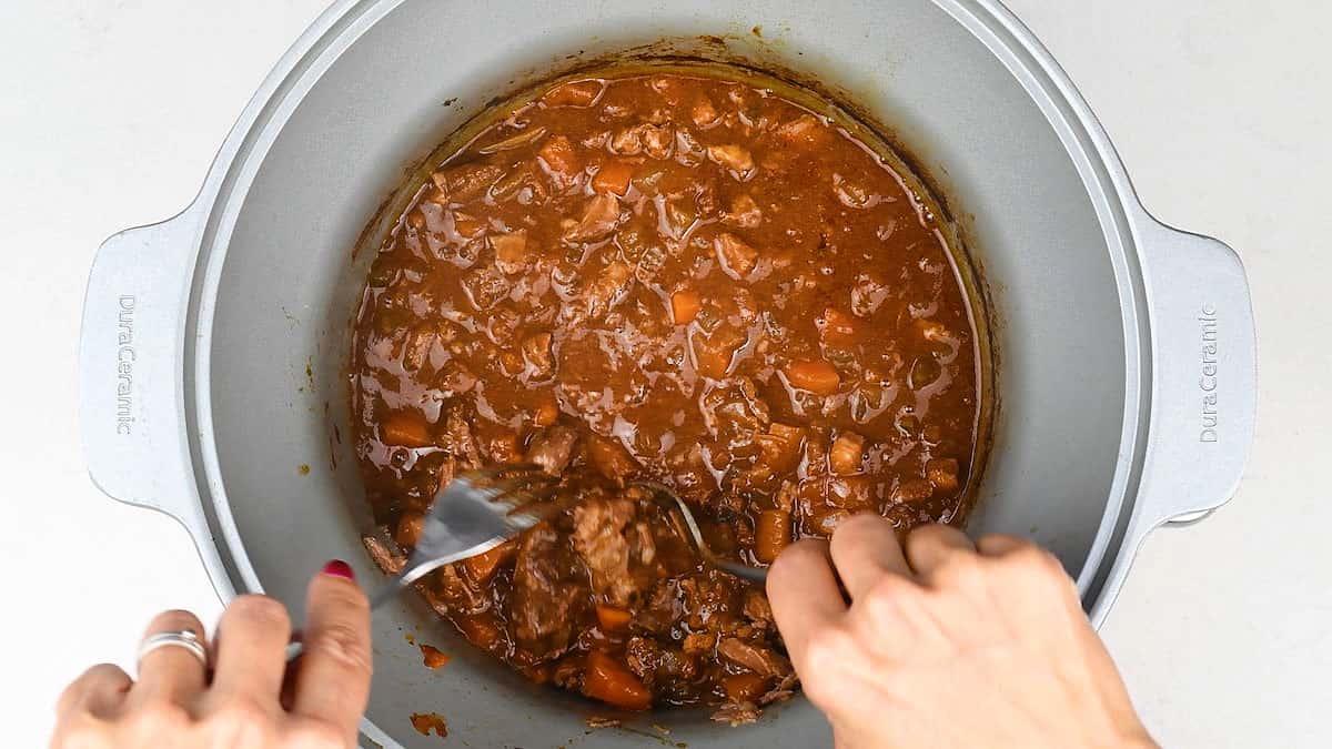 Shredding beef in ragu sauce
