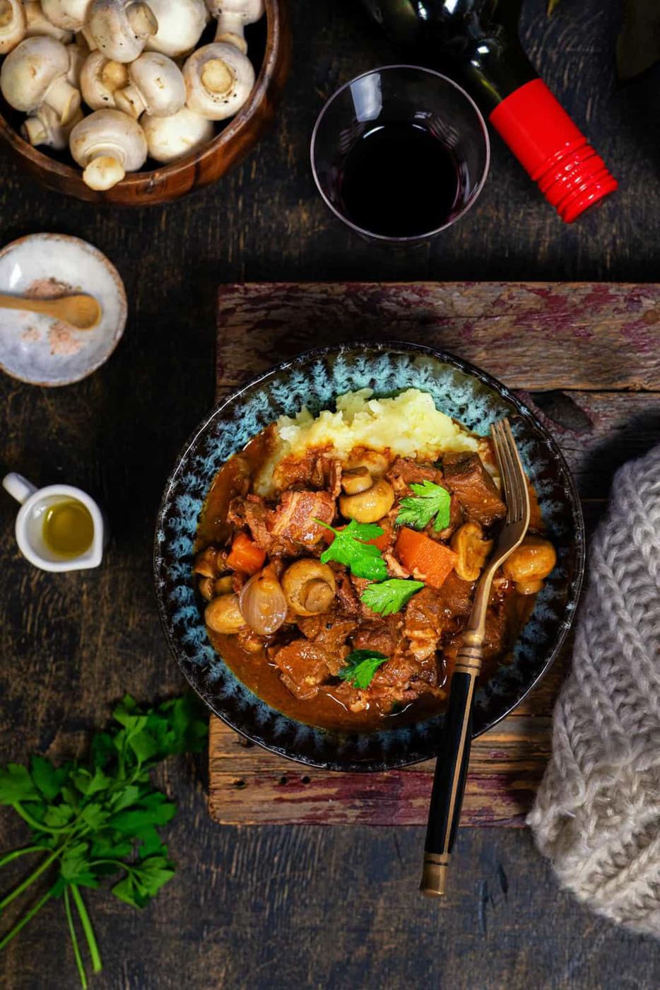 Beef Bourguignon served over mashed potatoes in a bowl