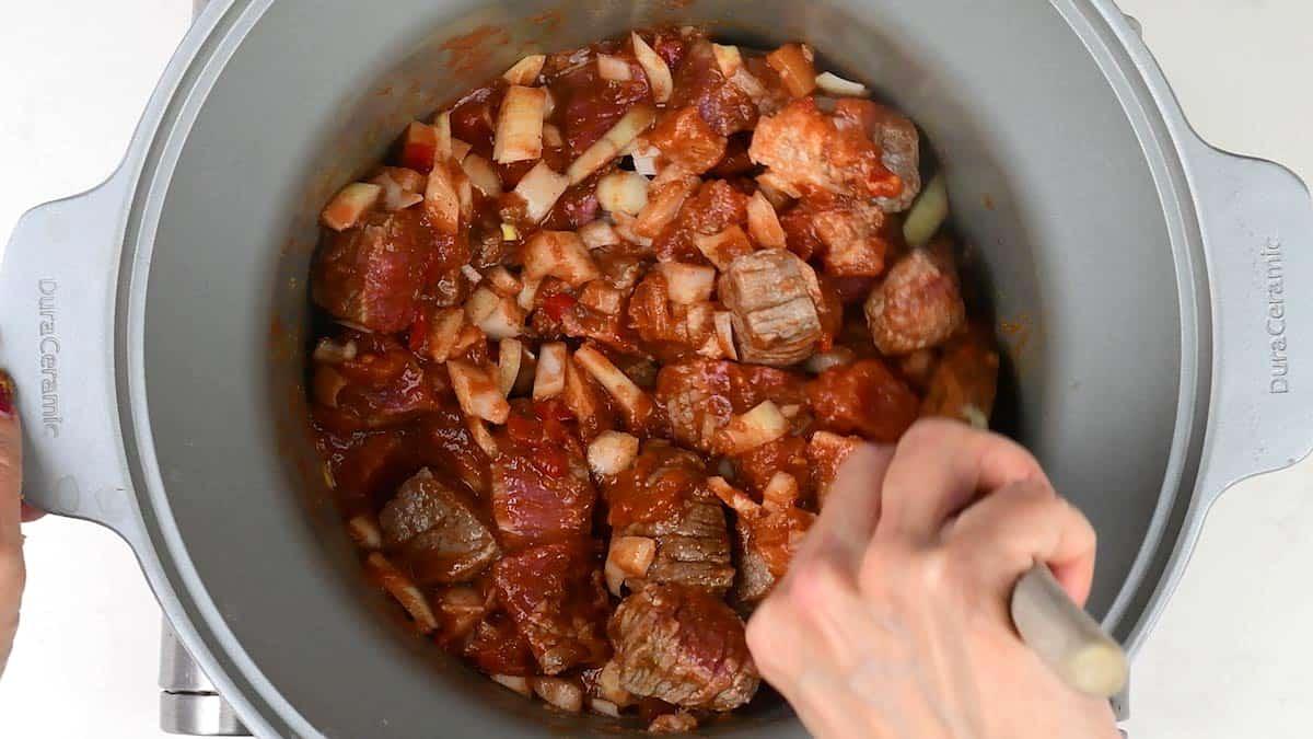 Stirring ingredients for curry in a slow cooker