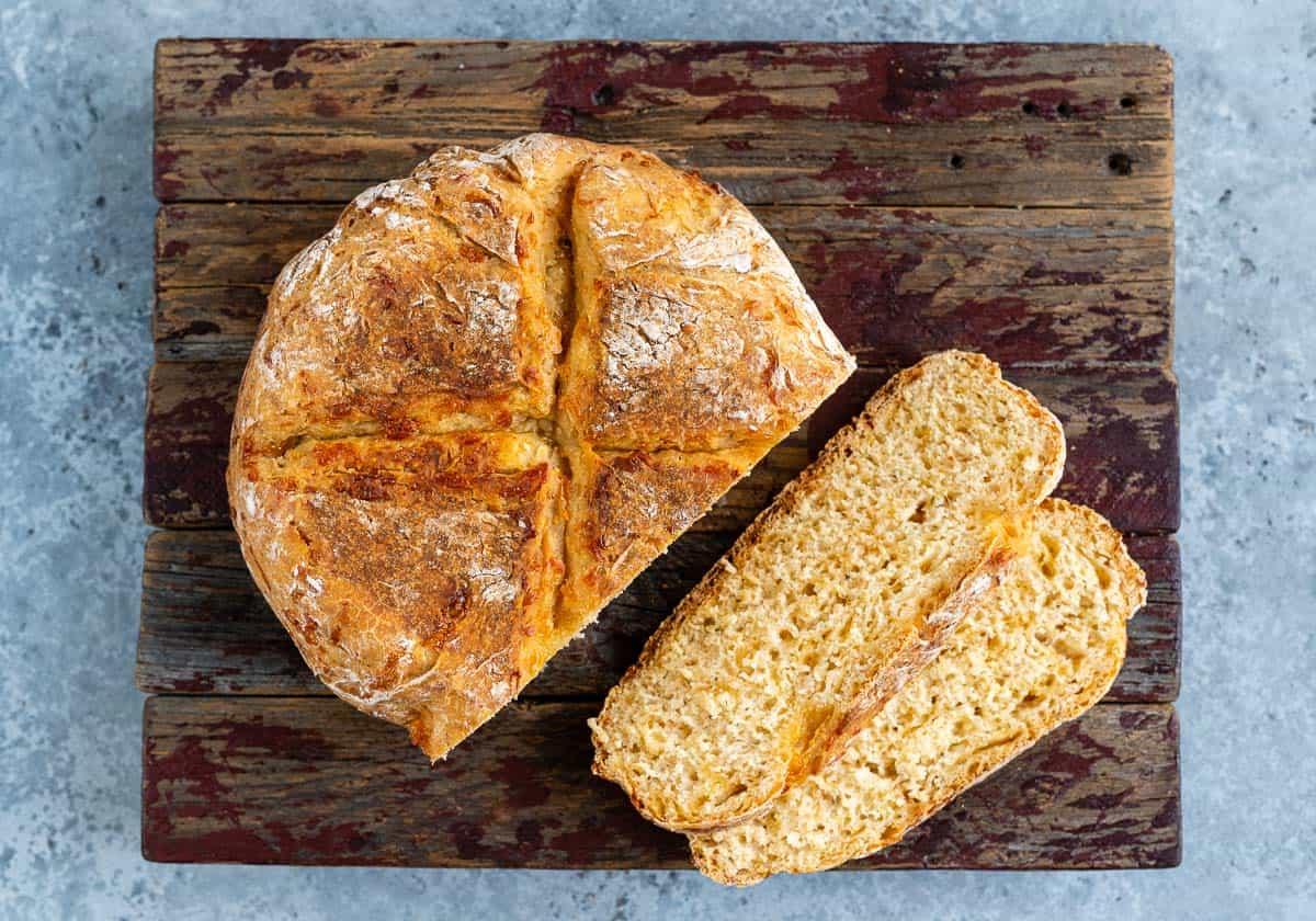 Slow cooker cheese bread sliced on a wooden board
