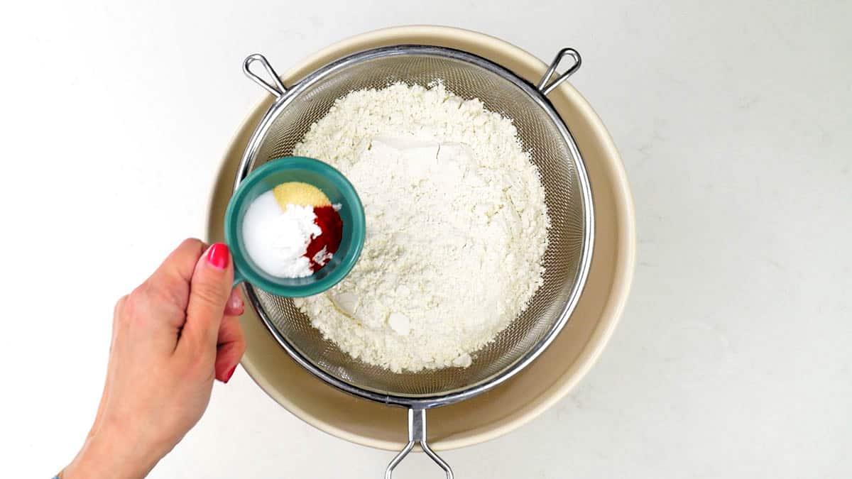 sifting dry ingredients for no yeast bread into a mixing bowl