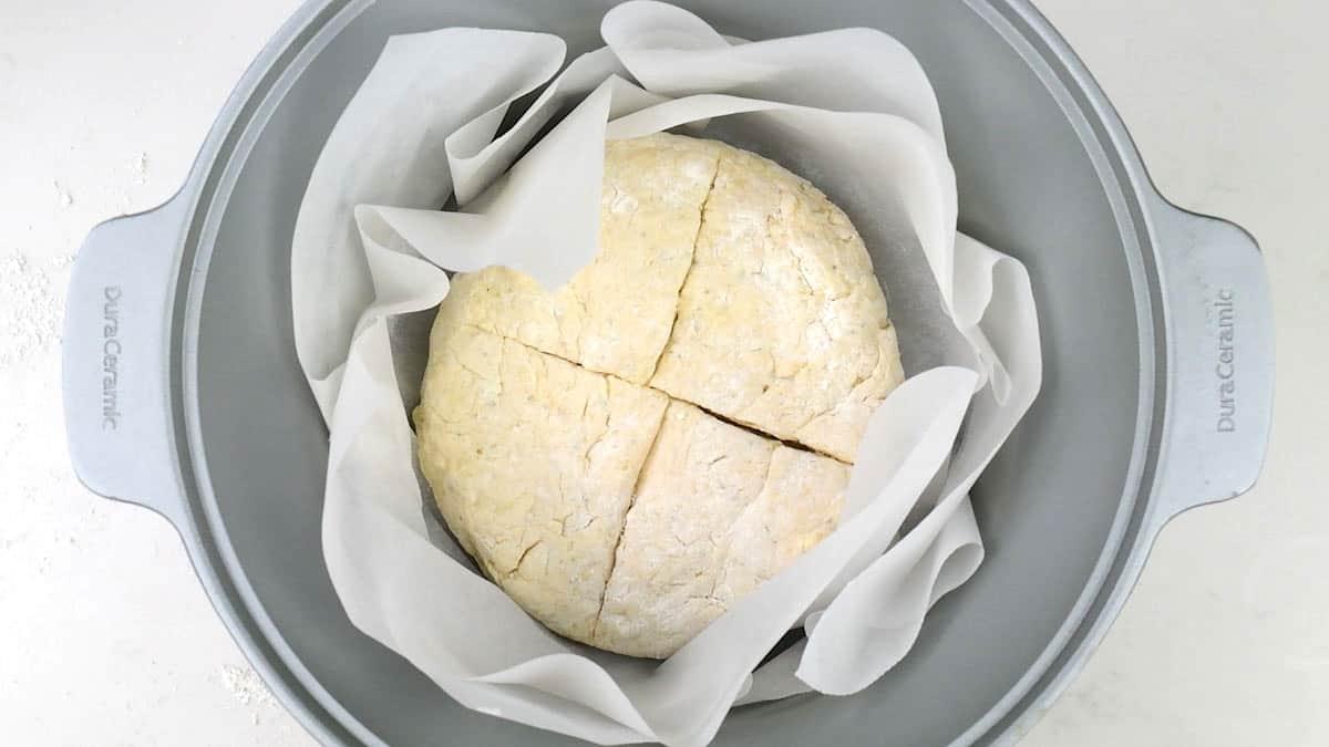 Unbaked round loaf in a slow cooker lined with baking paper