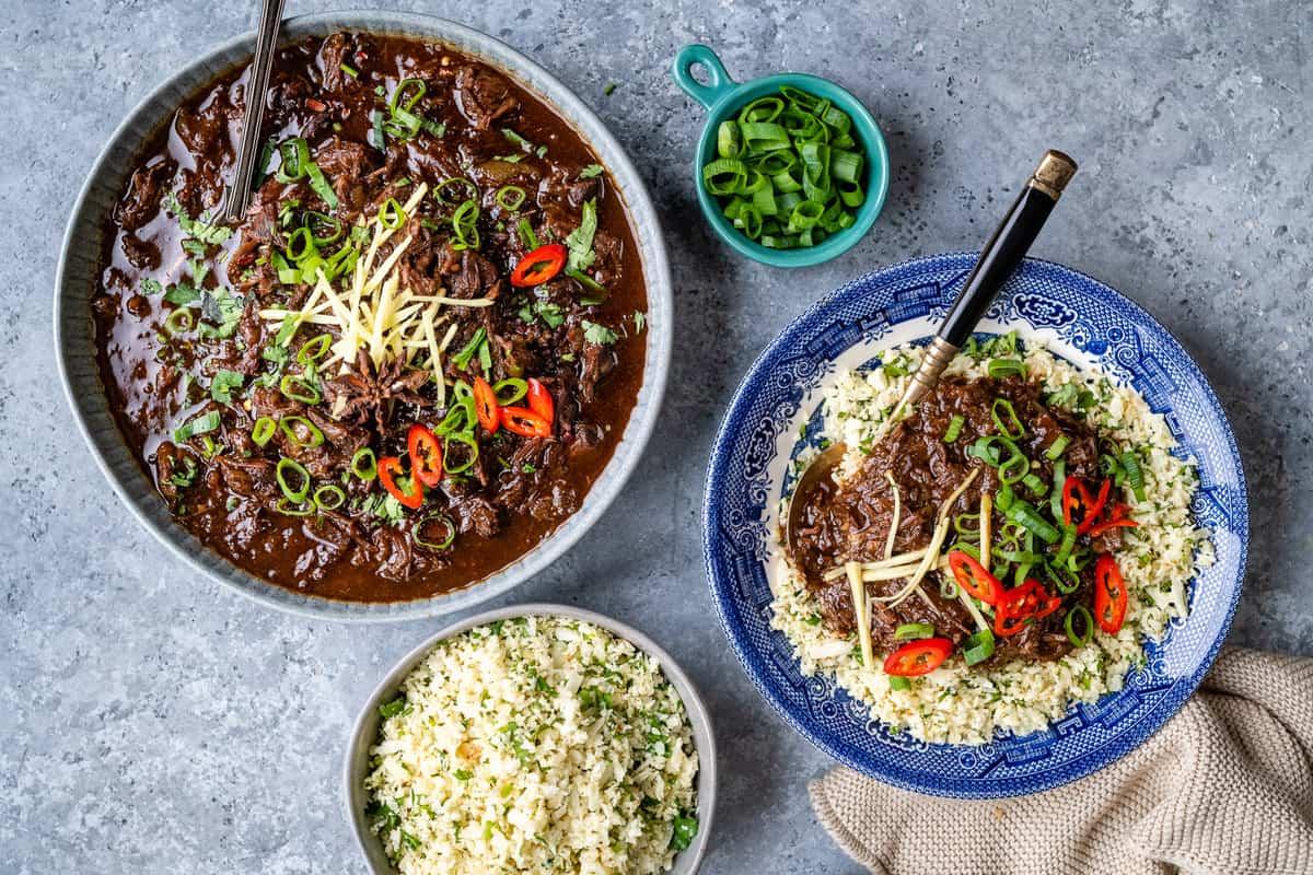 serving of soy braised Chinese shredded beef over cauliflower rice with bowl of shredded beef on side
