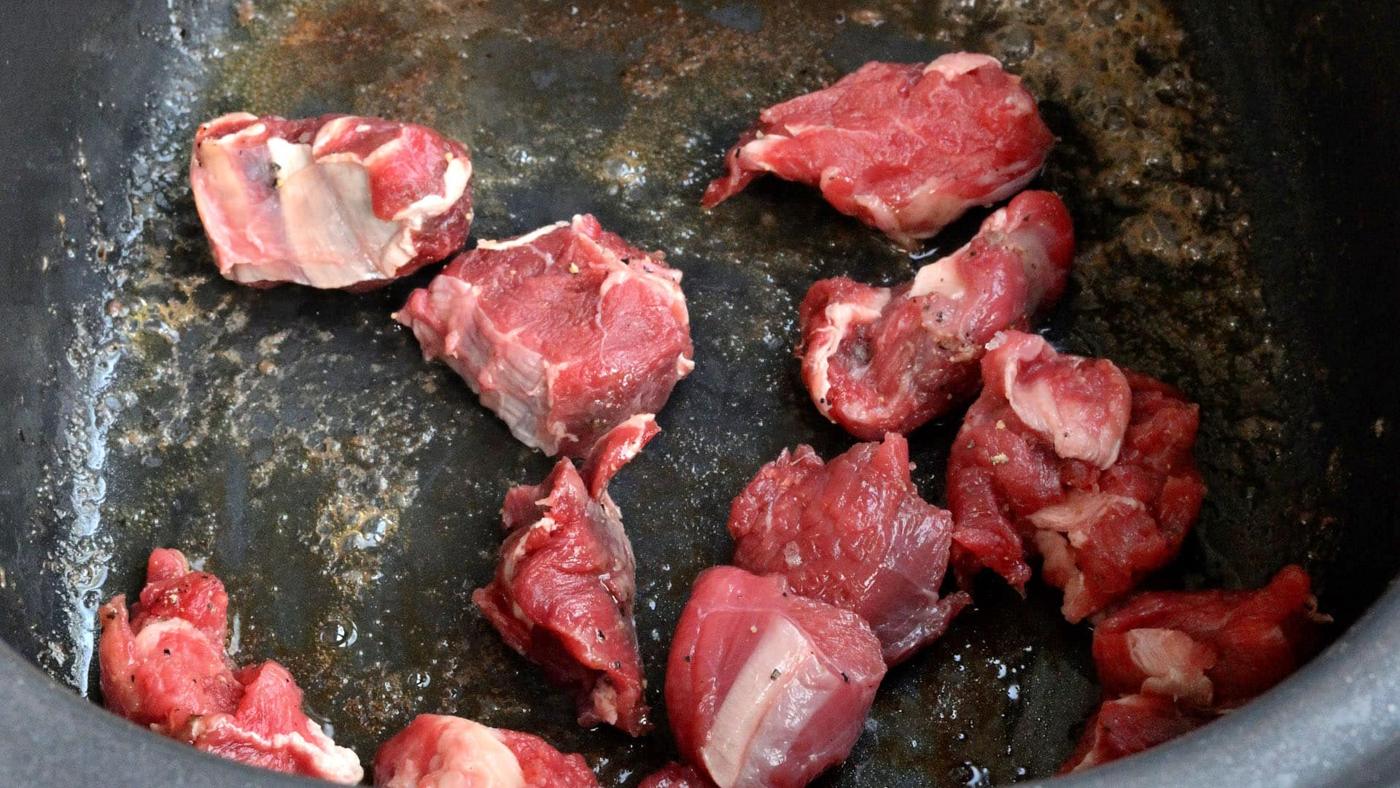 searing chunks of lamb, close up