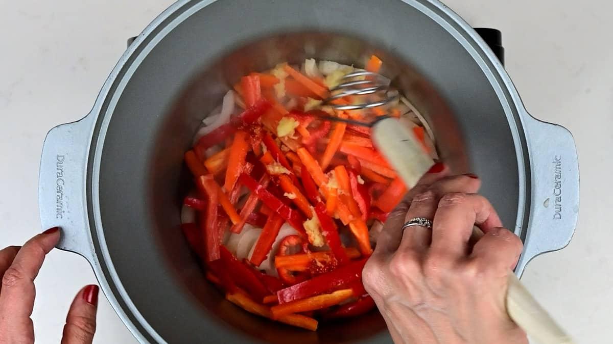 Stir frying onions and sliced red bell pepper
