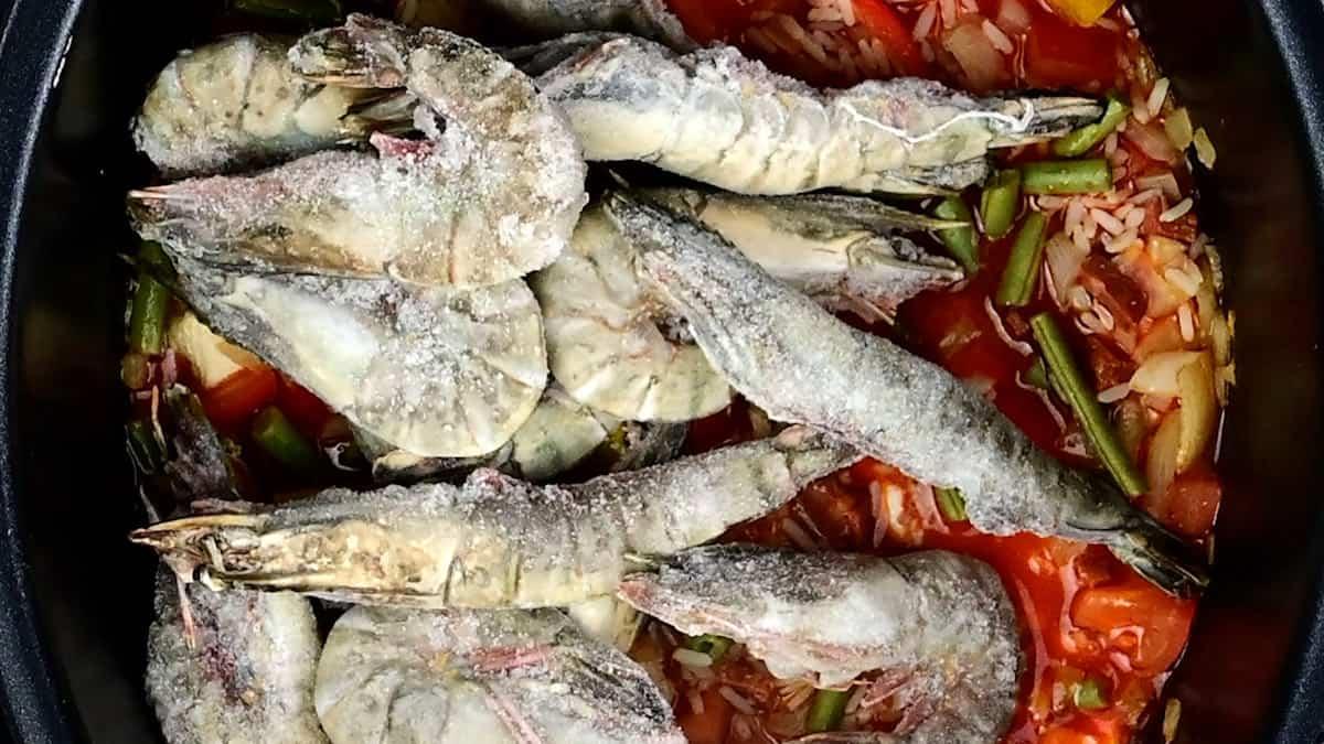 adding raw shrimp to slow cooker paella