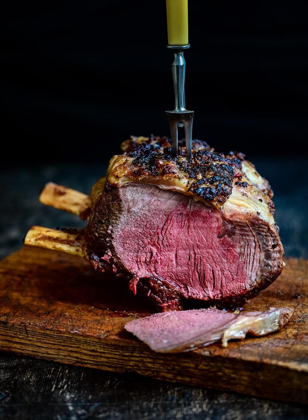 Rib of beef with slice cut out on a wooden board