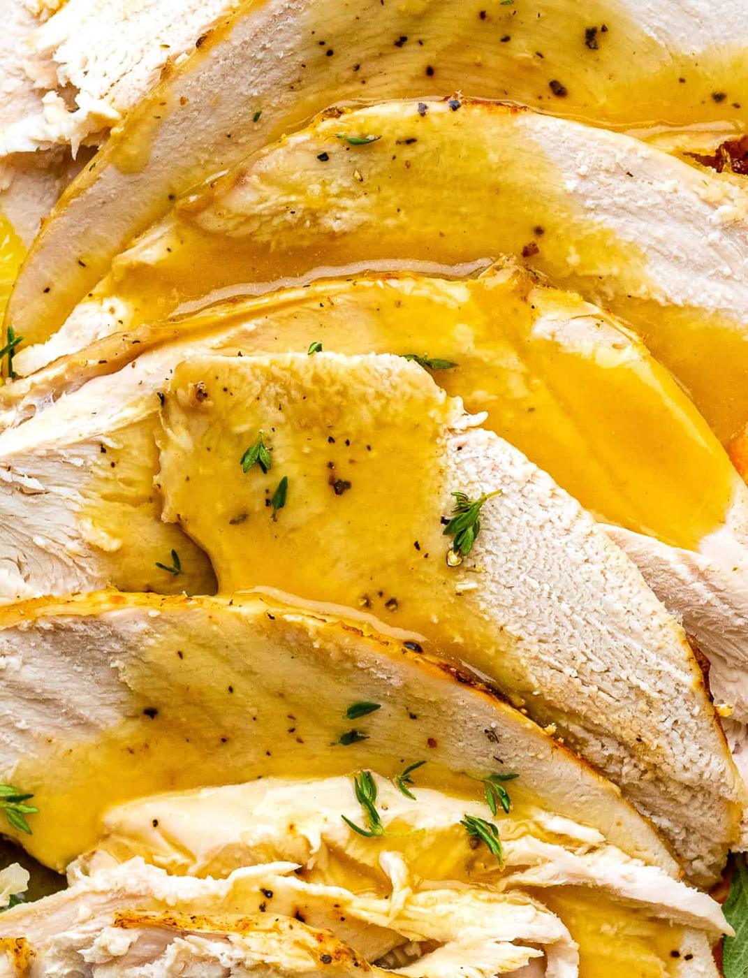 extreme close up on sliced turkey breast topped with gravy