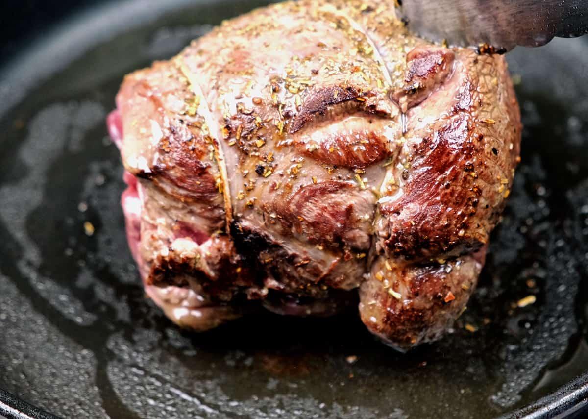 searing a venison joint in a skillet
