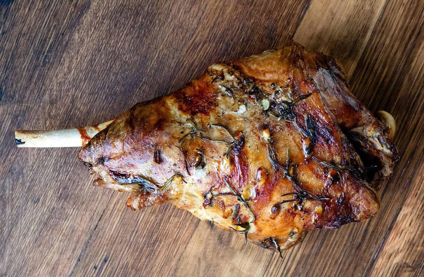 Roast leg of lamb on a wooden board