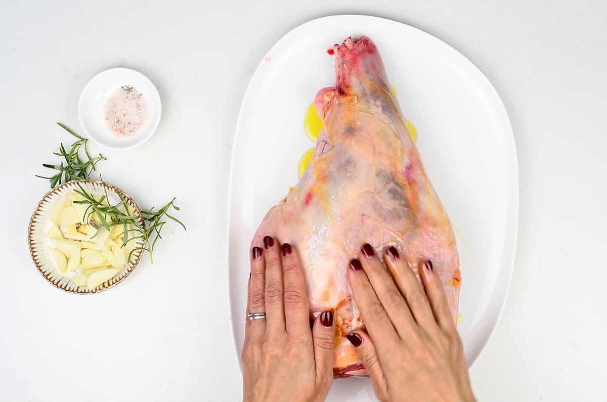 Rubbing lamb leg with oil