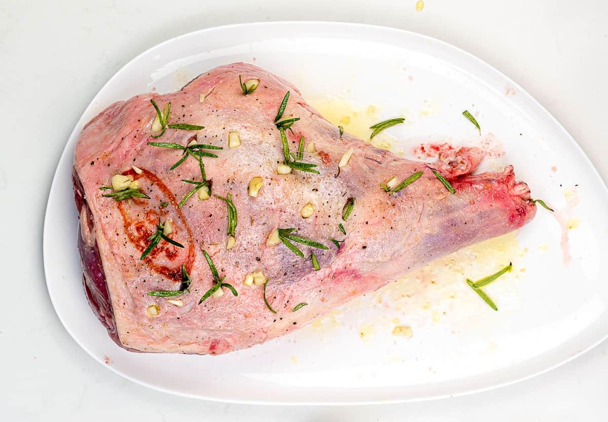 Adding rosemary and garlic to lamb leg