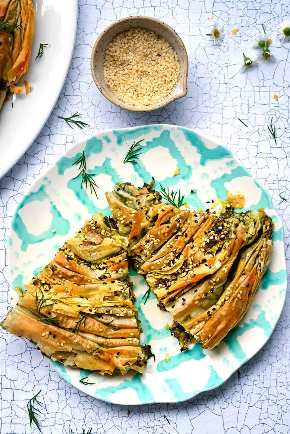 Two slices of spanakopita on a patterned plate