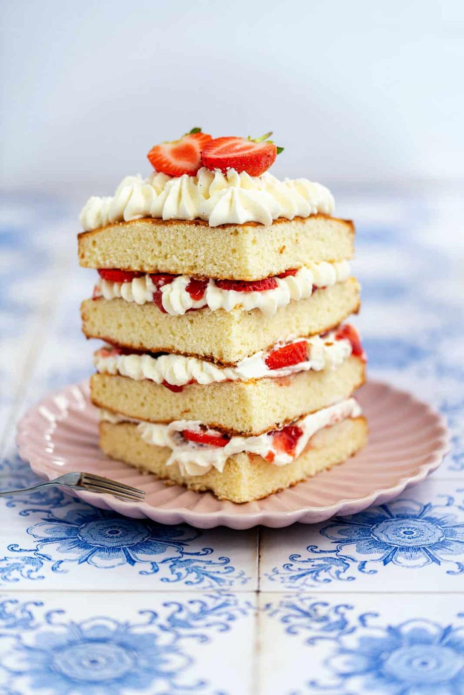 Sponge cake slice layered with fresh cream and strawberries