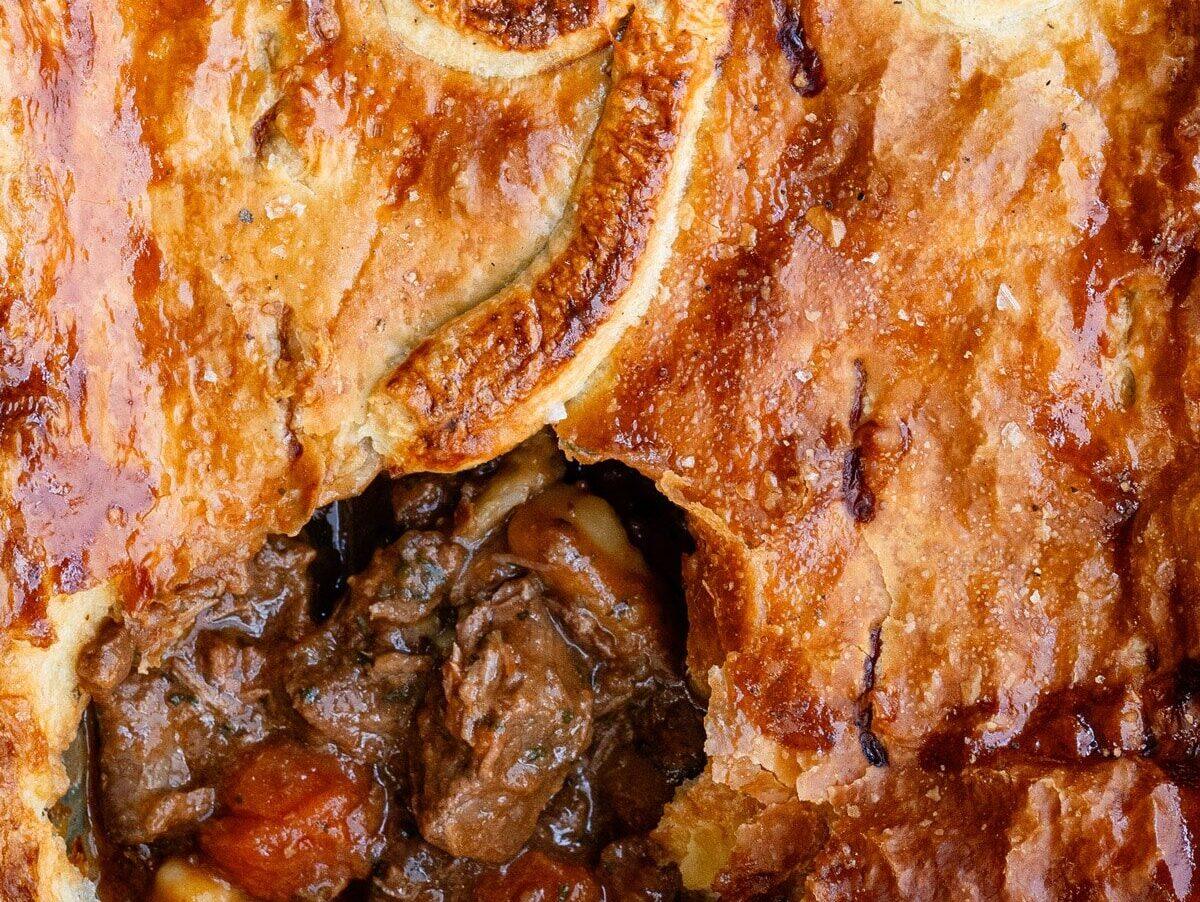 close up on the crust of a beef pie with puff pastry topping