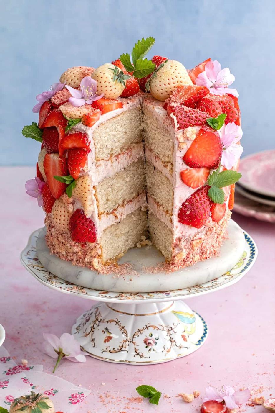 Fresh strawberry cake with slice cut out to show the layers