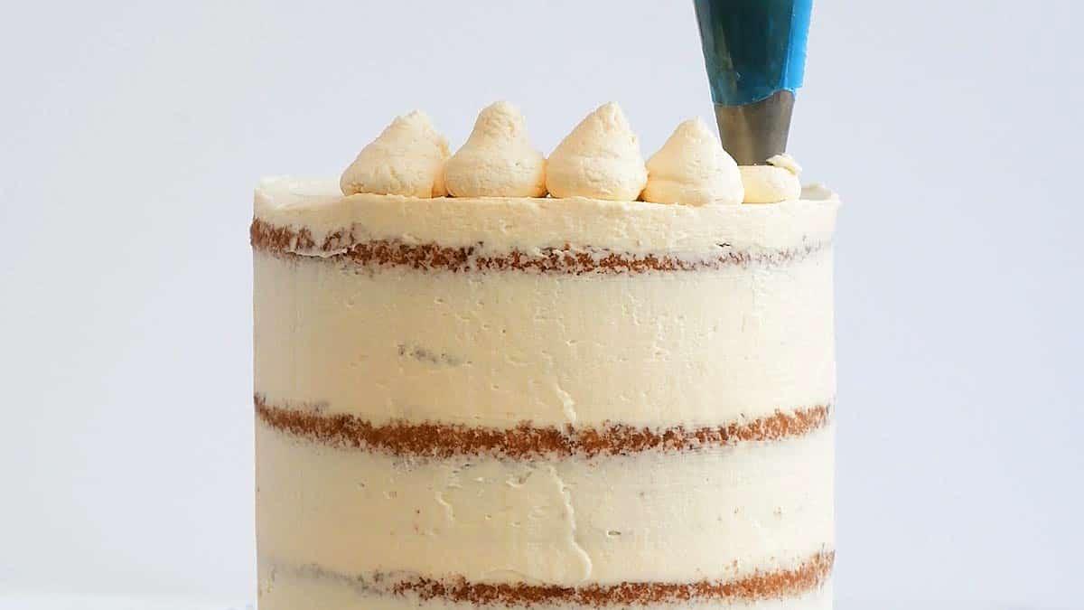piping frosting over cake