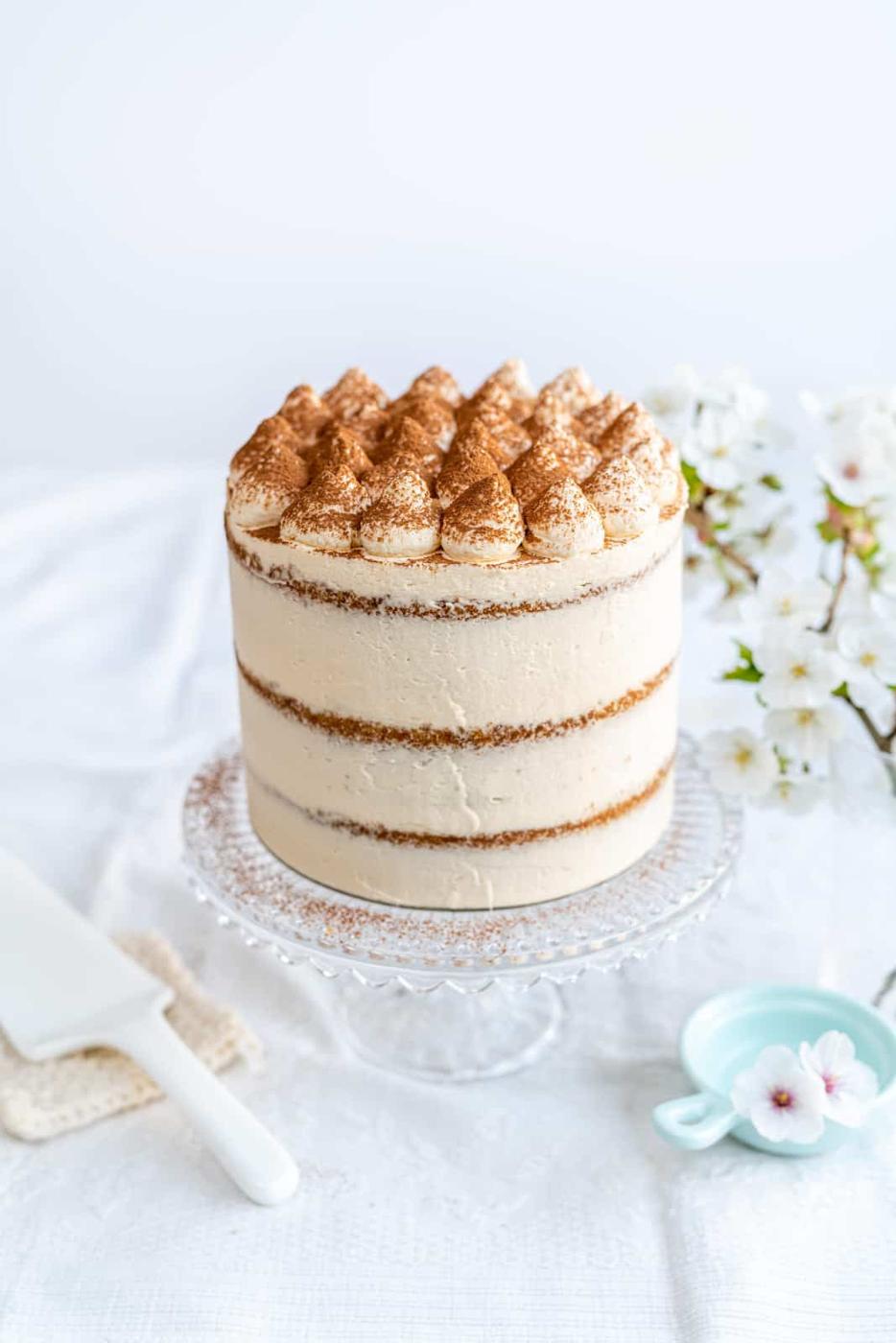 Tiramisu cake on a glass cake stand
