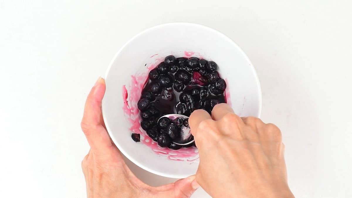 mixing blueberries and lemon juice in a small bowl