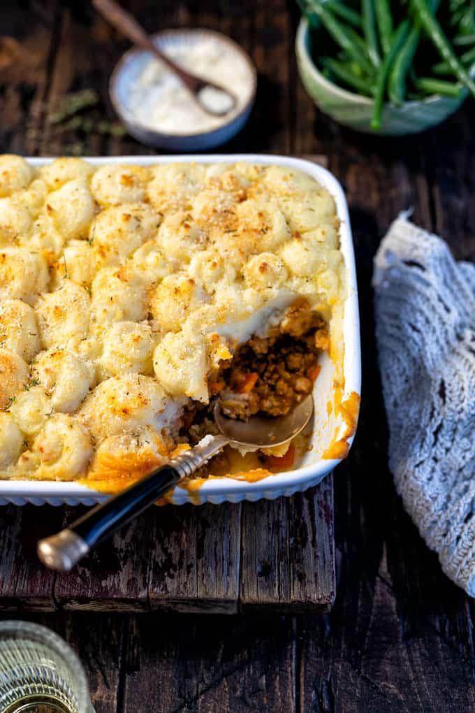 Shepherd’s Pie in a white ceramic dish with slice taken out side view