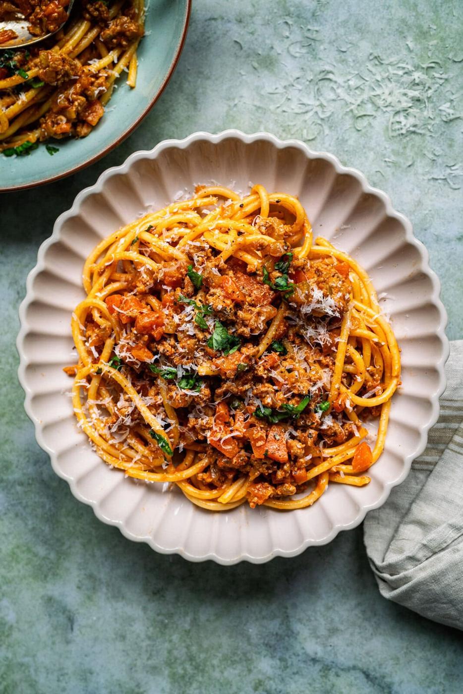 serving of pasta with Turkey Bolognese sauce, grated cheese and chopped basil garnish