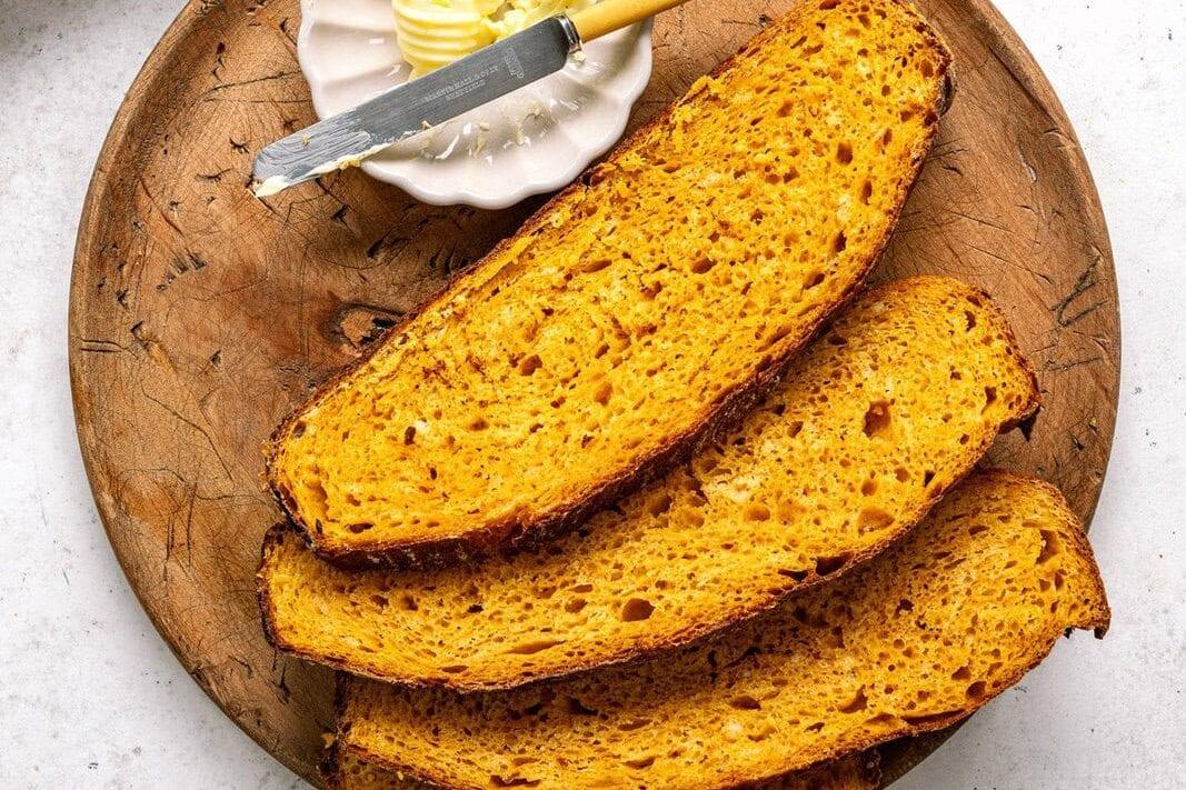 slices of no-knead pumpkin bread on a wooden plate